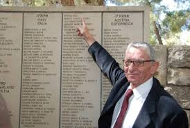 author in front of memorial of names